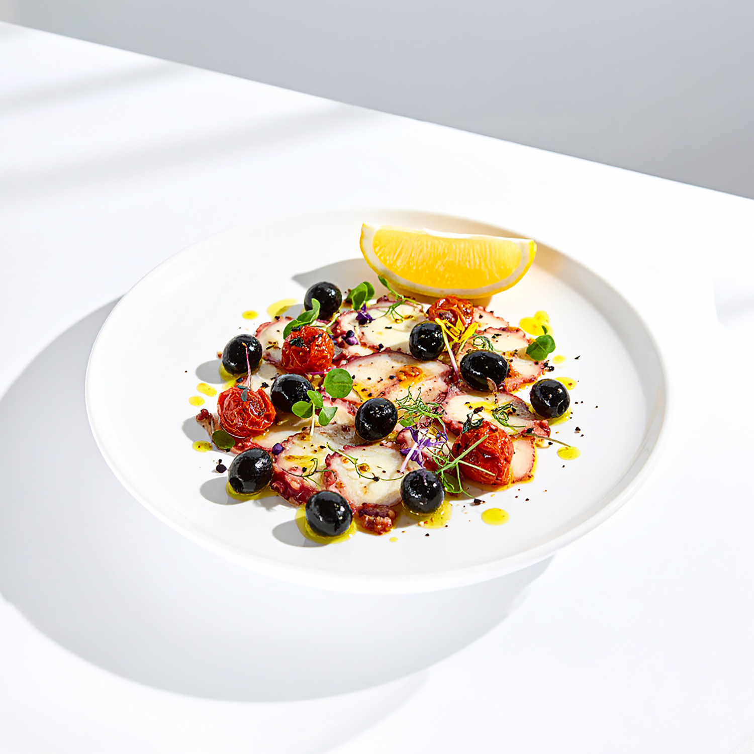 Carpaccio di Polpo mit confierten Tomaten und Oliven